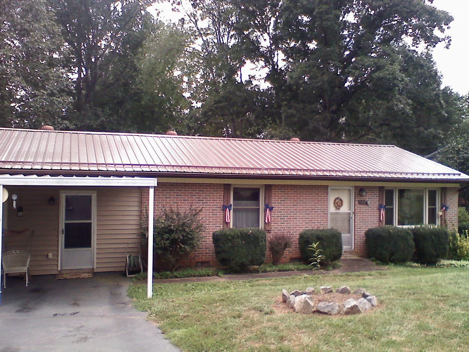Bronze metal roof and carport on a brick ranch home — Roof Repair work by our crew in Nora Springs