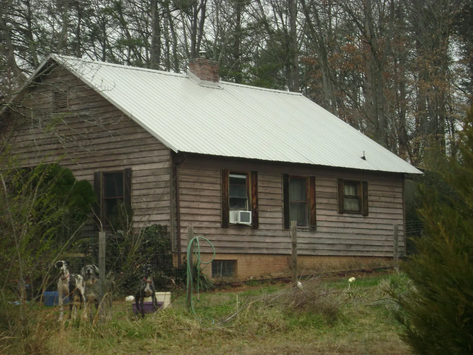 White metal roof on an old wood sided farmhouse, from a Metal Roof Installation job in Nora Springs